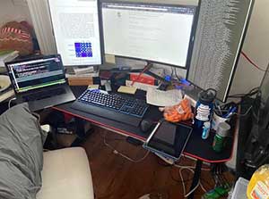 A student's work from home setup includes 4 different monitors. Two monitors are portrait and two are landscape oriented. 