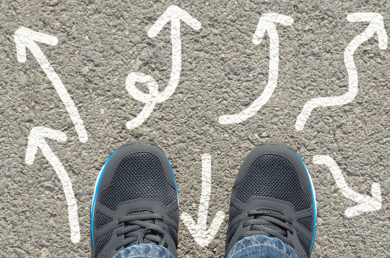 An image of feet with arrows symbolizing directions of a life course