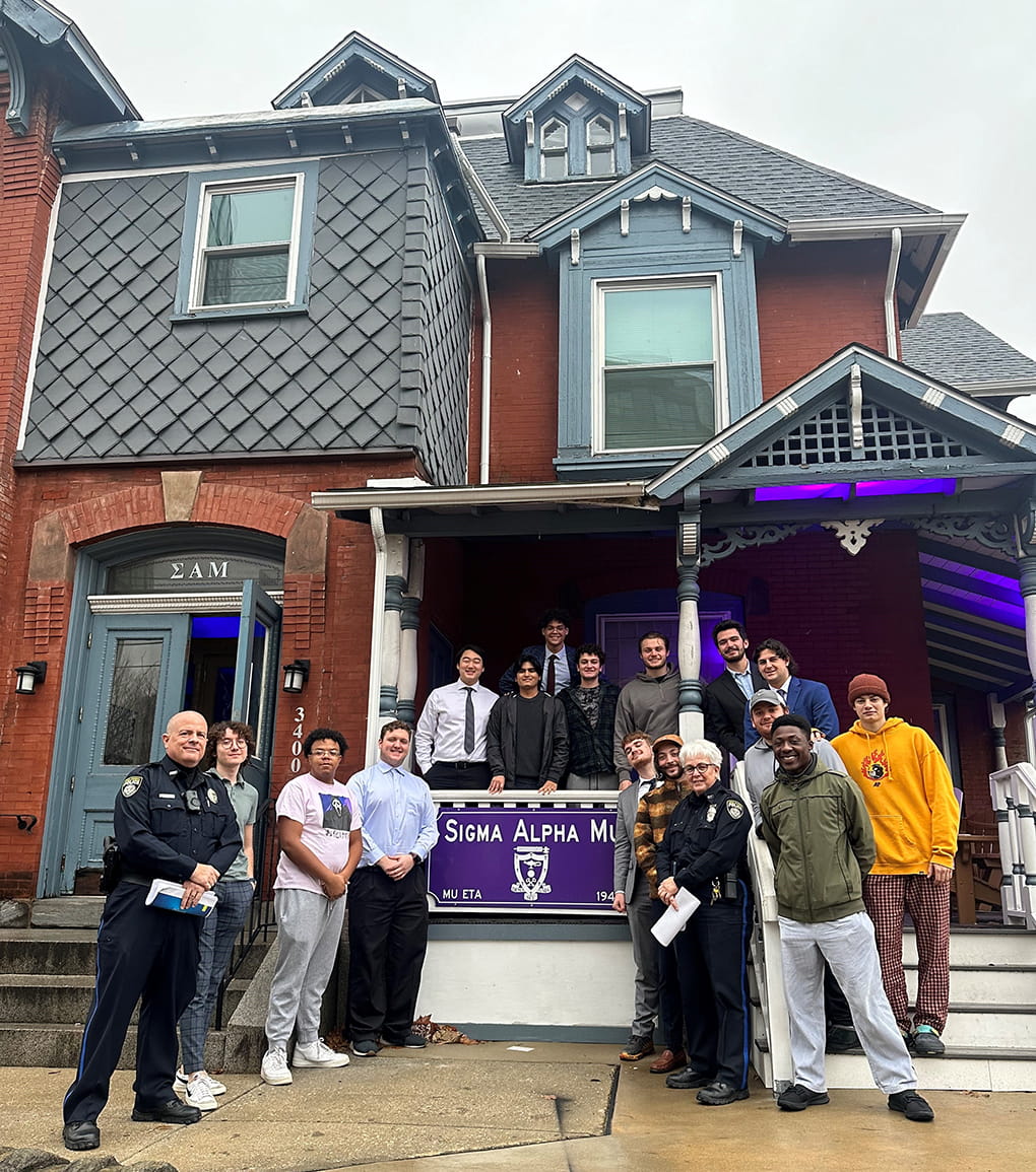 Drexel Public Safety officers and students in front of a house.