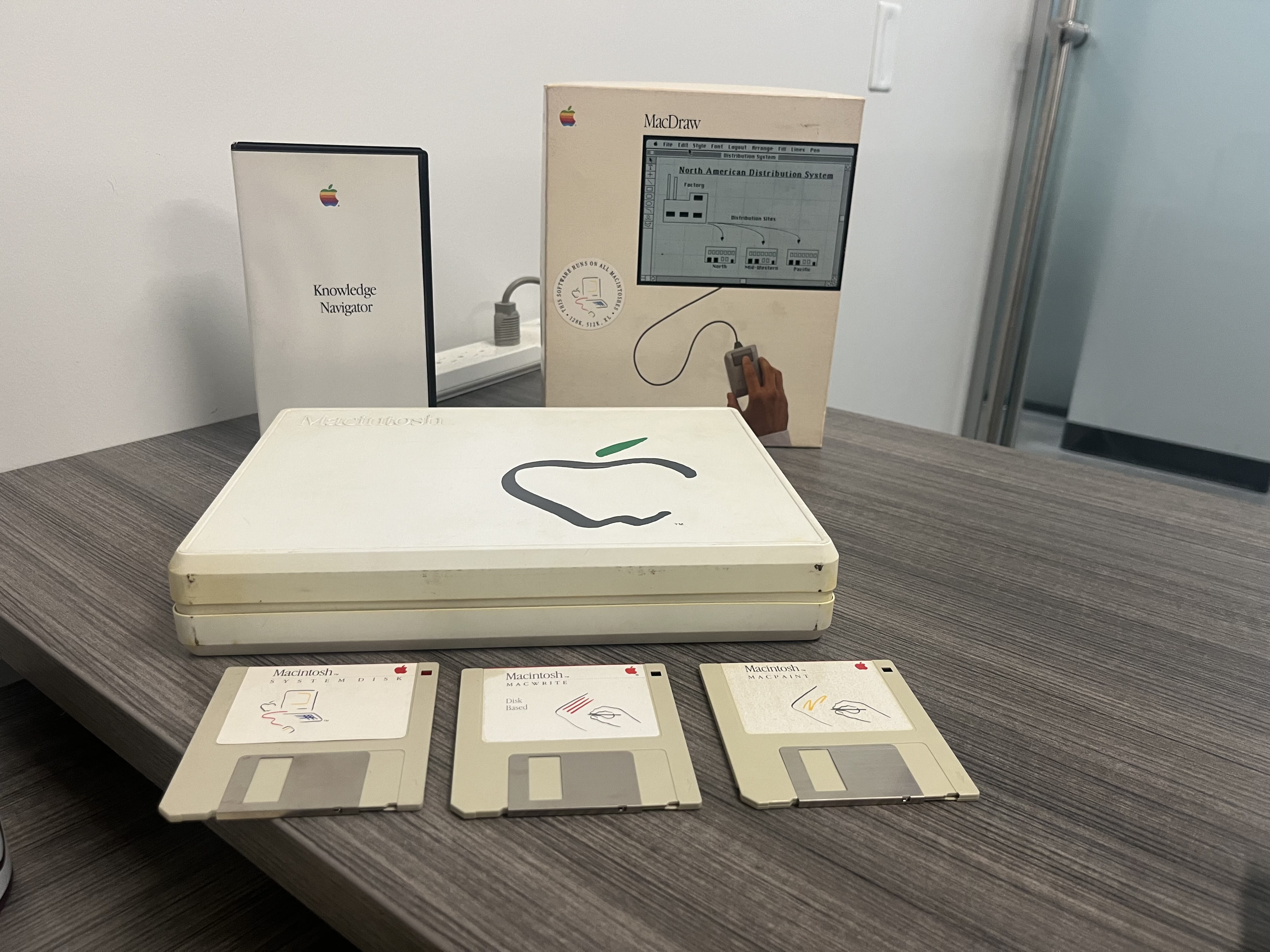 Some of the Macintosh components held in the Compuseum, including a MacDraw package, a “Knowledge Navigator” VHS tape, and recreated software disks for a Macintosh systems disk, MacWrite and MacPaint.