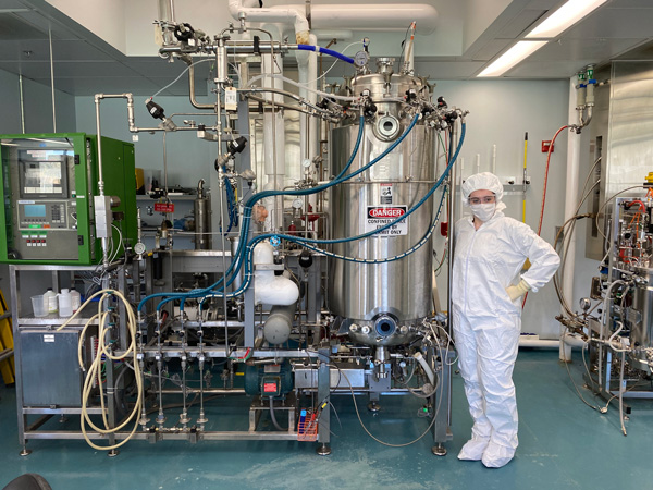 Angela Mamatas (Biomedical Engineering) stands next to a 400-L bioreactor