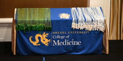 AOA and GHHS cords on a table draped with College of Medicine tablecloth