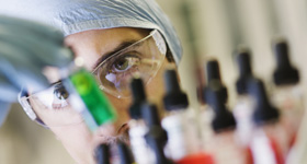 Animal science laboratory technician looking at vials.