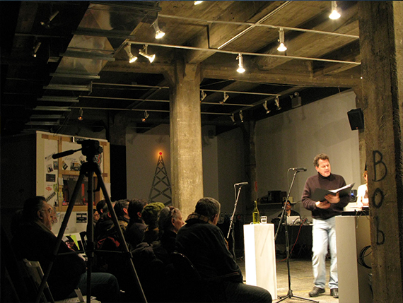 'NEXUSradio' by Nick Cassway, a speaker on stage addresses an audience and camera. 