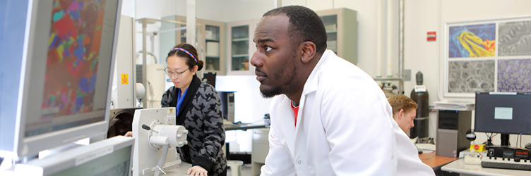 Drexel graduate students working in a biomedical research lab; one student is watching a monitor closely.